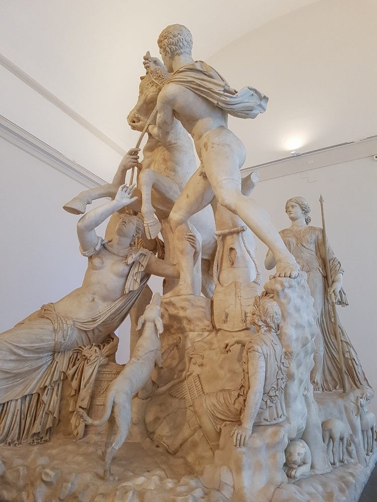 A close up of the Farnese Bull sculpture, showing the shepherd and his excited dog.