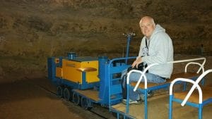 Thomas Dowson sitting on the electric train in Rouffignac Cave.